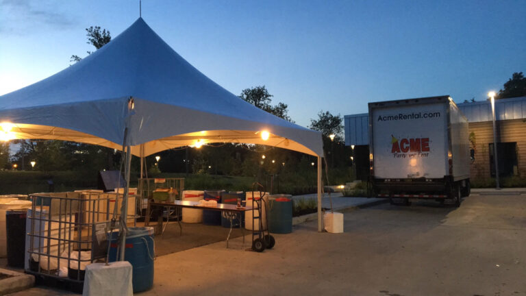 ACME Party and Tent delivery truck and tent at a Houston event site at dusk