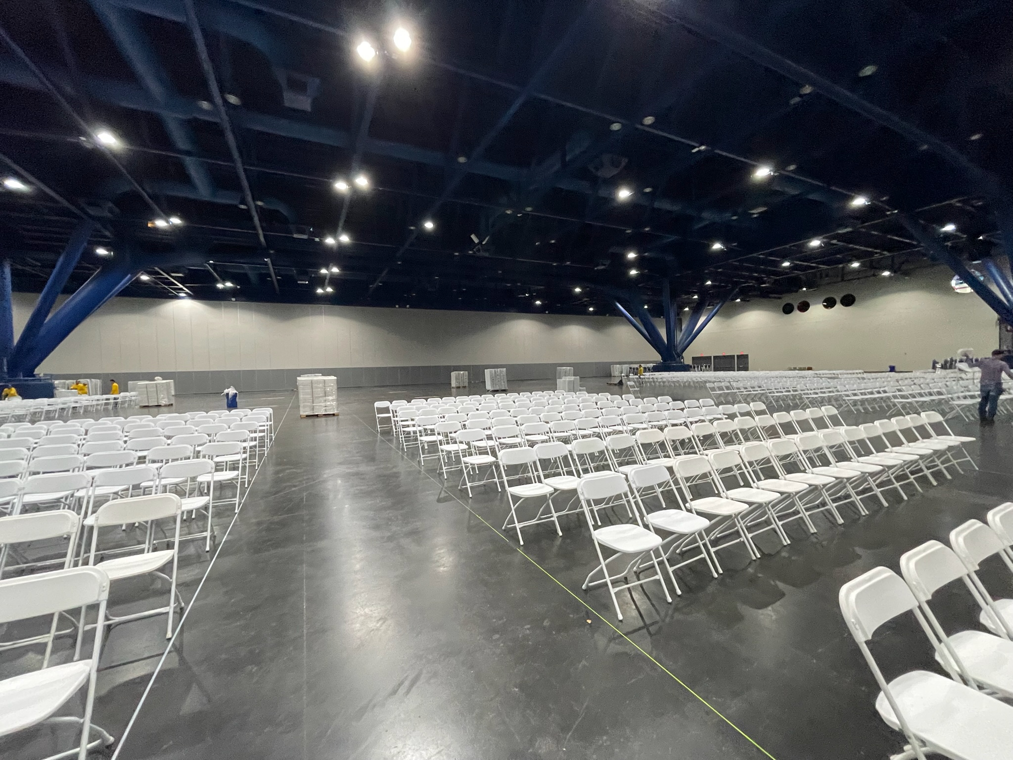 Rows of white event chairs set up for a large ceremony in Houston