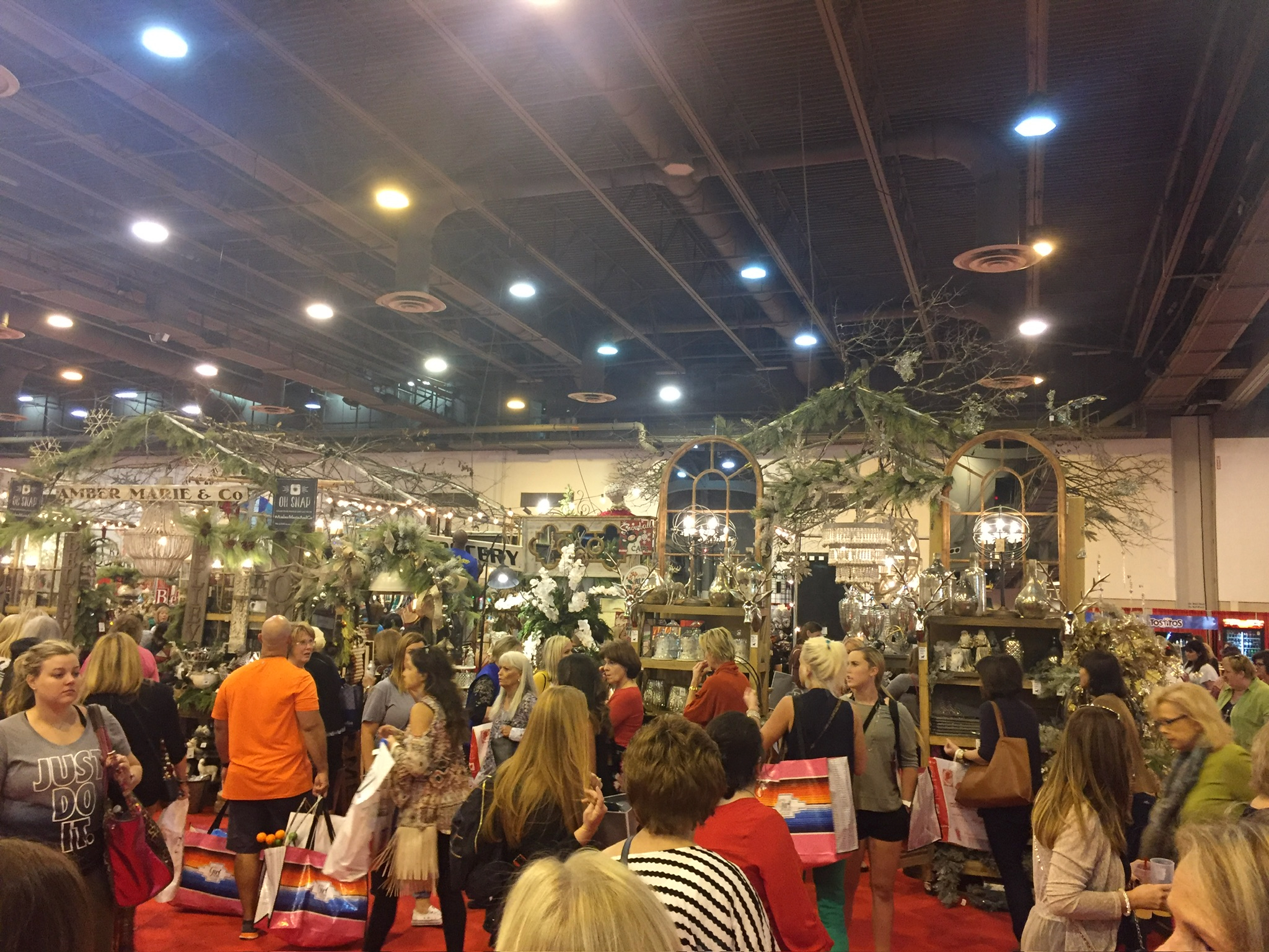 Exhibitors and attendees inside a Houston convention hall under event lighting